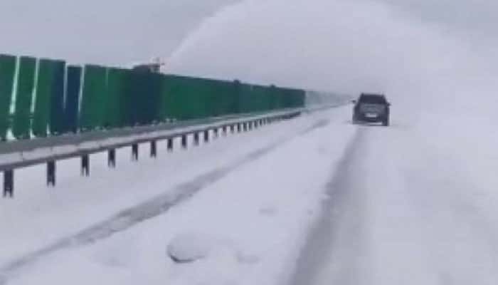 Utilaj de deszăpezire filmat pe autostradă cum aruncă zăpada de pe un sens pe altul